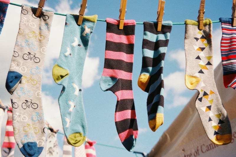 a bunch of colorful socks hanging on a clothes line