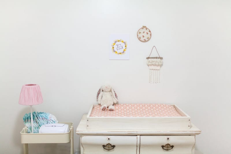 a room with a changing table and a lamp