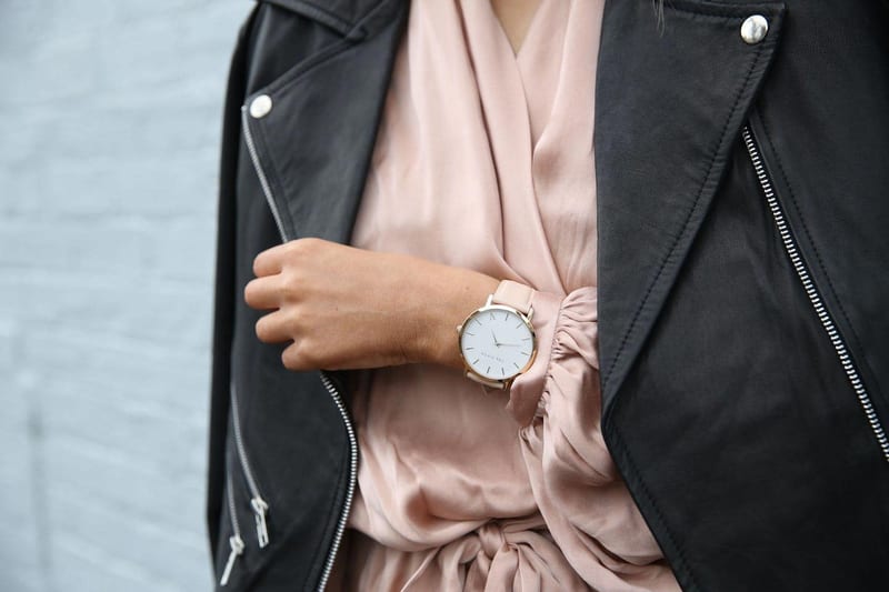 a woman wearing a leather jacket and a watch on her wrist