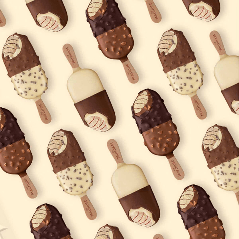 Pattern of Magnum ice cream bars with chocolate, white chocolate, and nuts on beige background