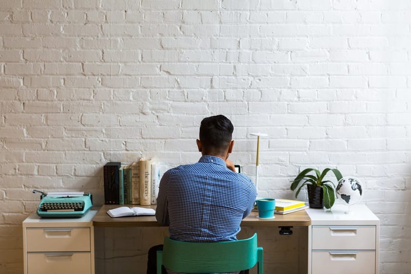 a man sits at a desk with a book titled the insects
