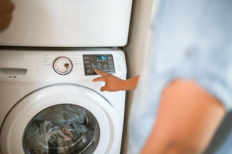 a person is pressing a button on a washing machine