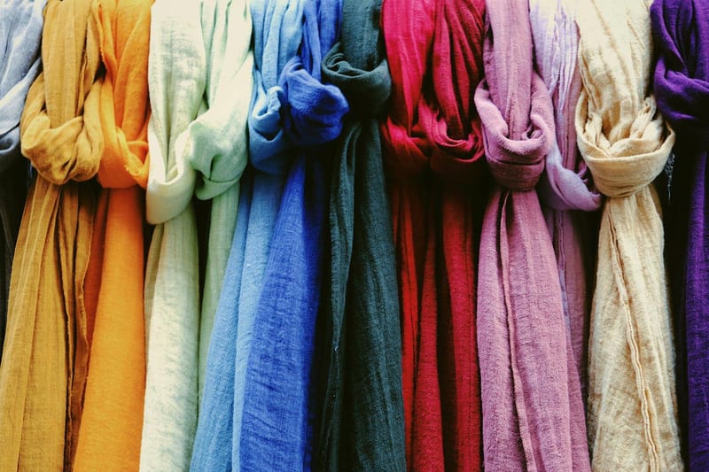 a row of colorful scarves hanging on a rack