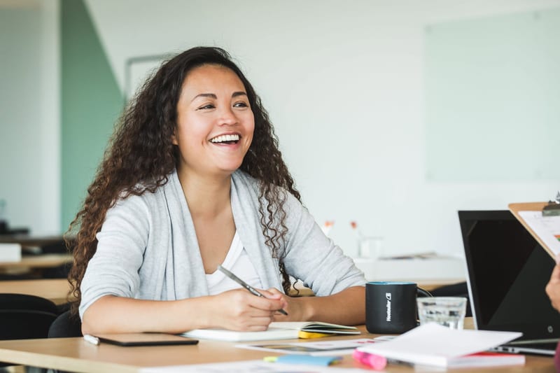 a woman sits at a desk with a mug that says foundation on it