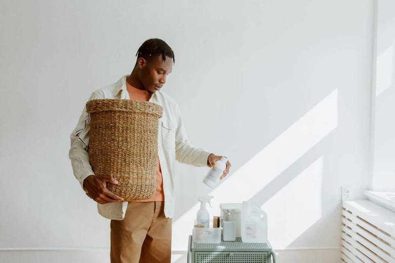a man is holding a wicker basket and pouring liquid into it