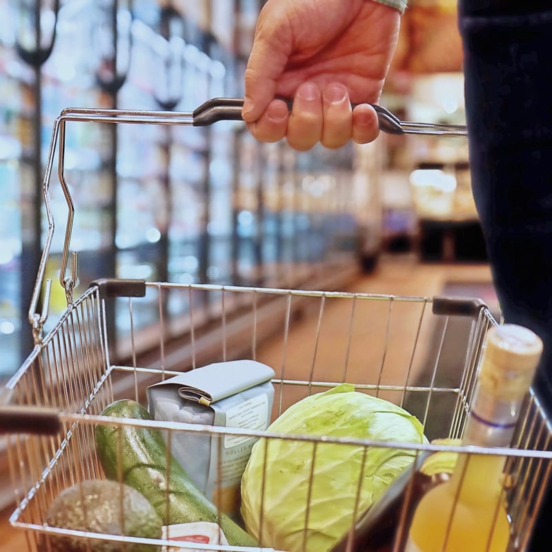 a person is pushing a shopping cart full of groceries in a grocery store