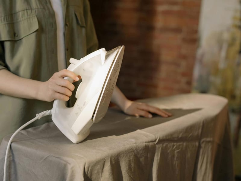 a person is ironing a piece of cloth on an ironing board
