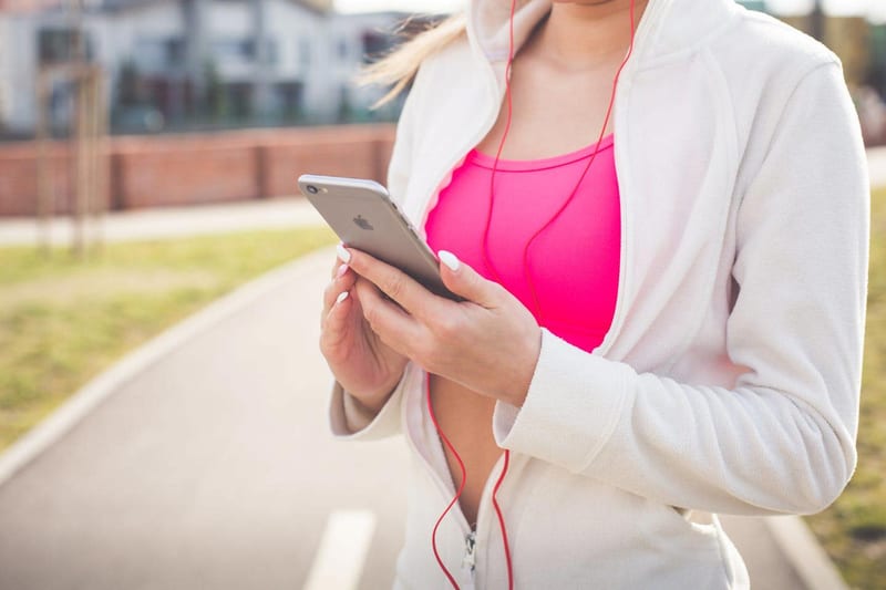 a woman wearing headphones is looking at her phone