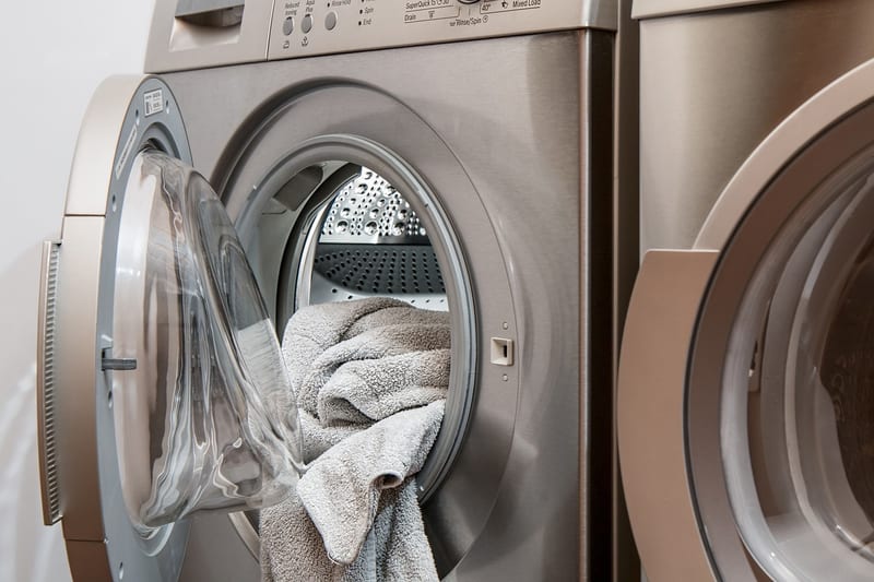 a washing machine with the door open and a towel in it
