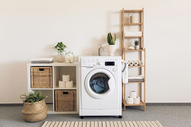 a white washing machine is sitting in a laundry room