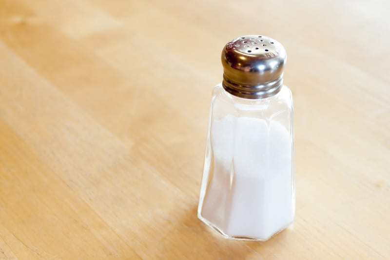 a salt shaker is sitting on a wooden table