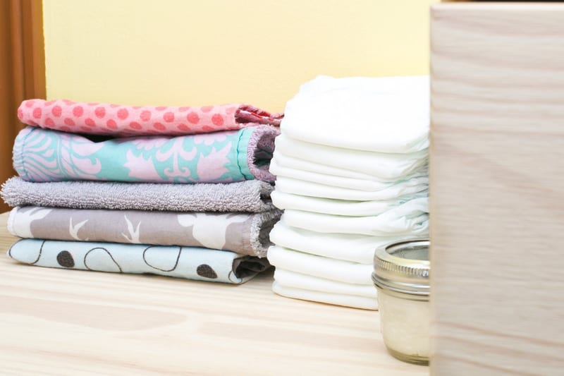 a stack of towels next to a stack of diapers